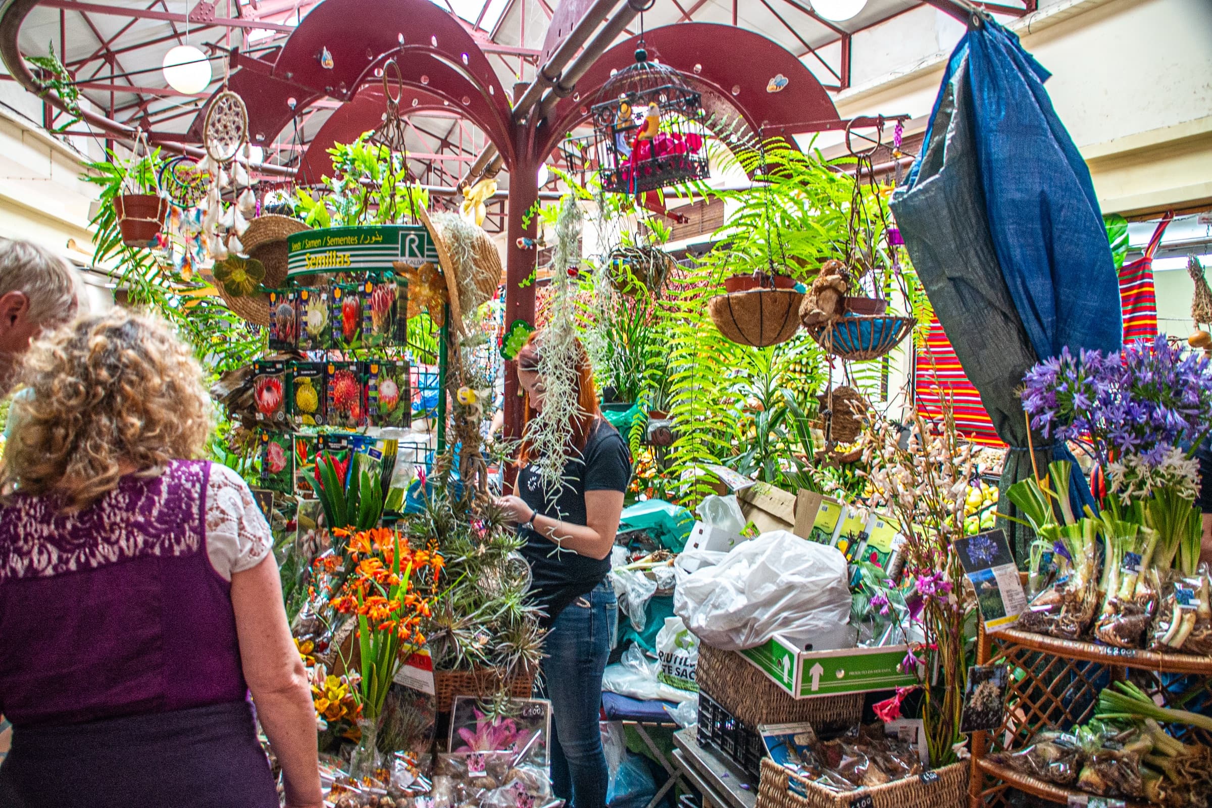 Shoppers browse a flower stall full of orchids and bird-of-paradise flowers in Funchal’s Mercado dos Lavradores.