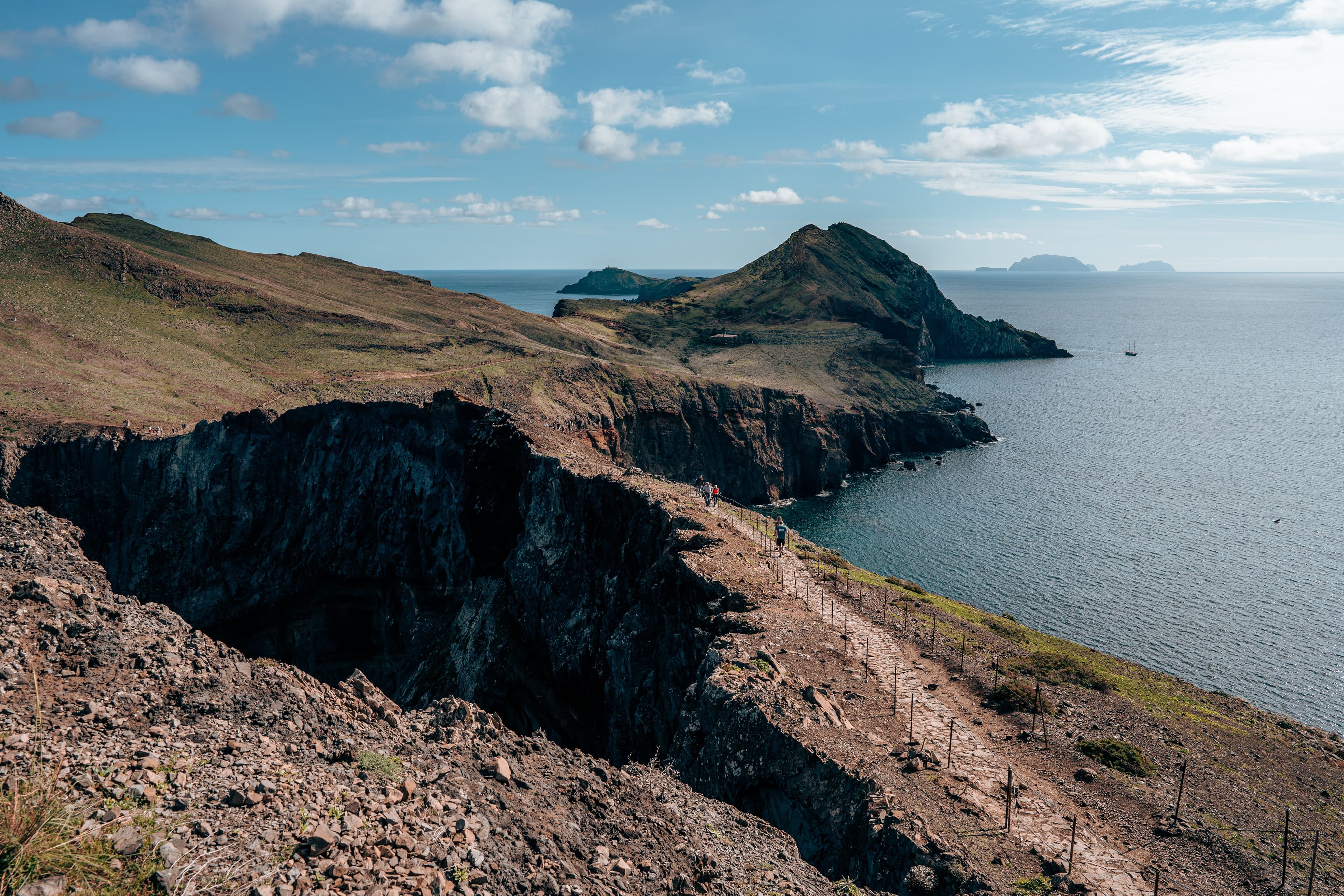 The bare volcanic ridges of the Ponta de São Lourenço peninsula run out into a calm blue sea.